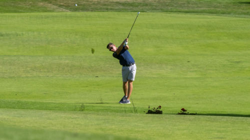 kille som slår ett golf slag på en golfbana i uppsala